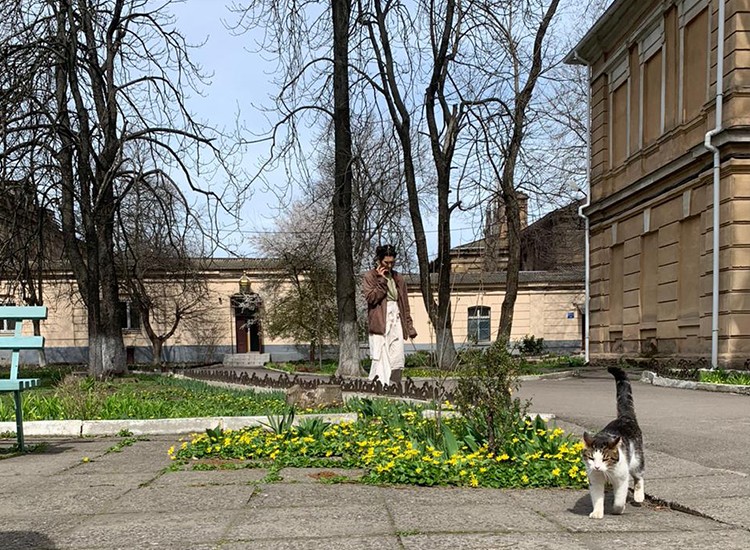 woman walking with cat in foreground in Odessa