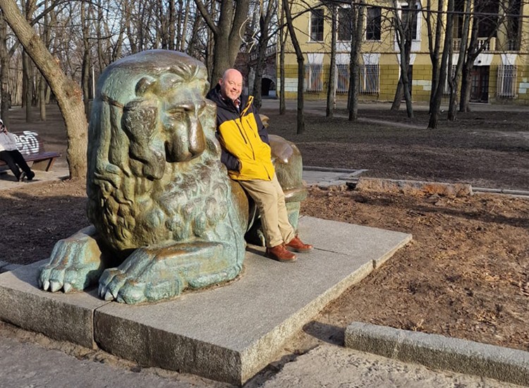 Gary Campbell leaning on a statue in Dnipro